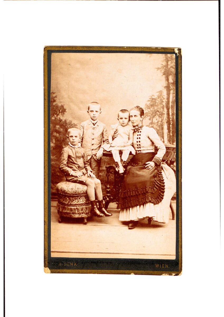Rudolf Denk, Mutter mit Tochter und zwei Söhnen vor einer Fototapete (von rechts nach links), I…
