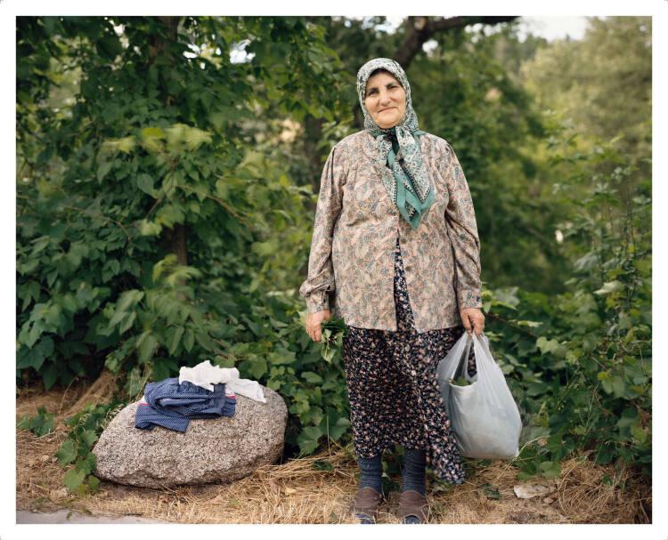 Joel Sternfeld, A Woman Picking Grape Leaves on the Banks of the Boulder Creek, Boulder Colorad…