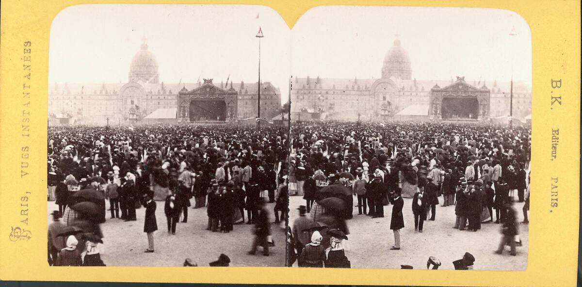 Menschenmenge vor einem Puppentheater, im Hintergrund die Kuppel des Invalidendoms in Paris, In…