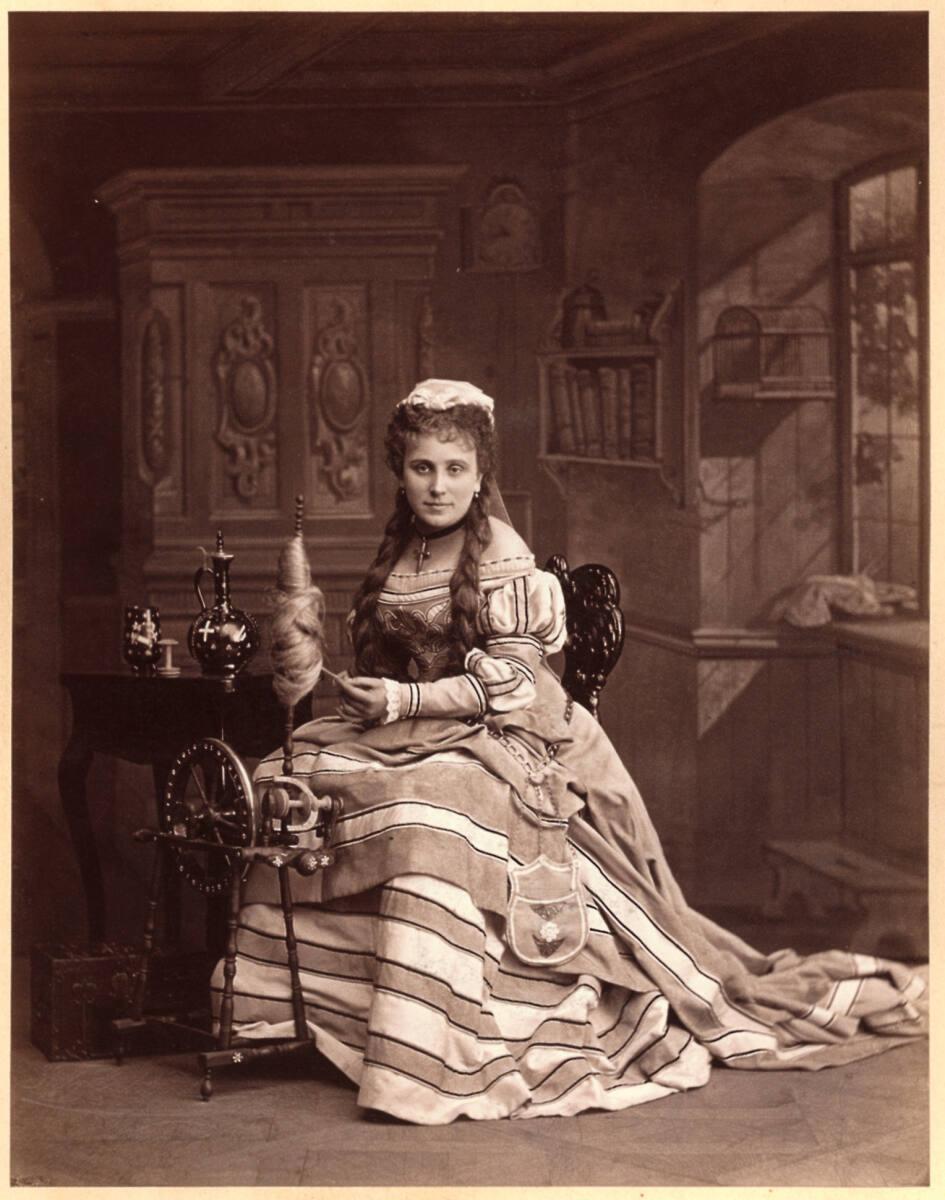 Fritz Luckhardt, Frau an einem Spinnrad, vor gemaltem Atelierhintergrund, Inv. Nr.: FotoGLV2000…